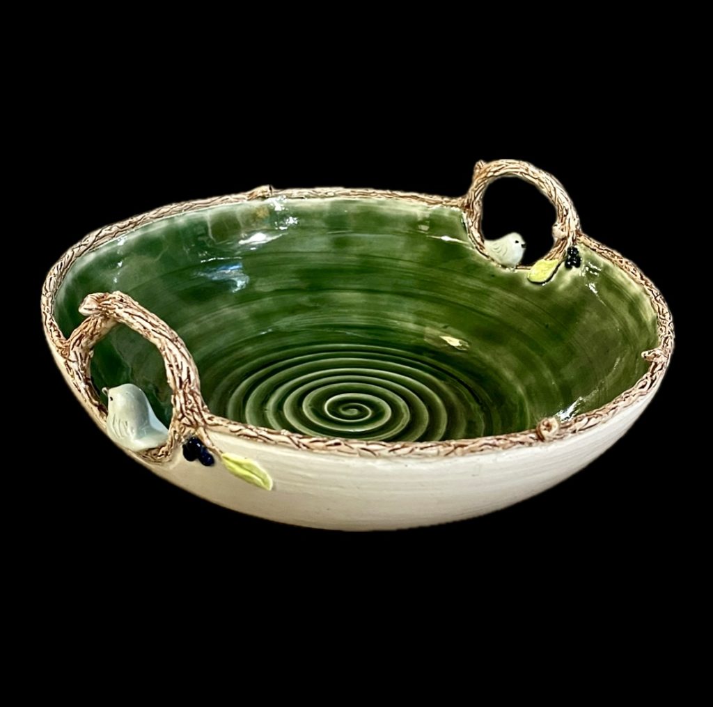 Centerpiece bowl in cream and green, with carved and sculpted branch and bird design. Measures approximately 8” in diameter.