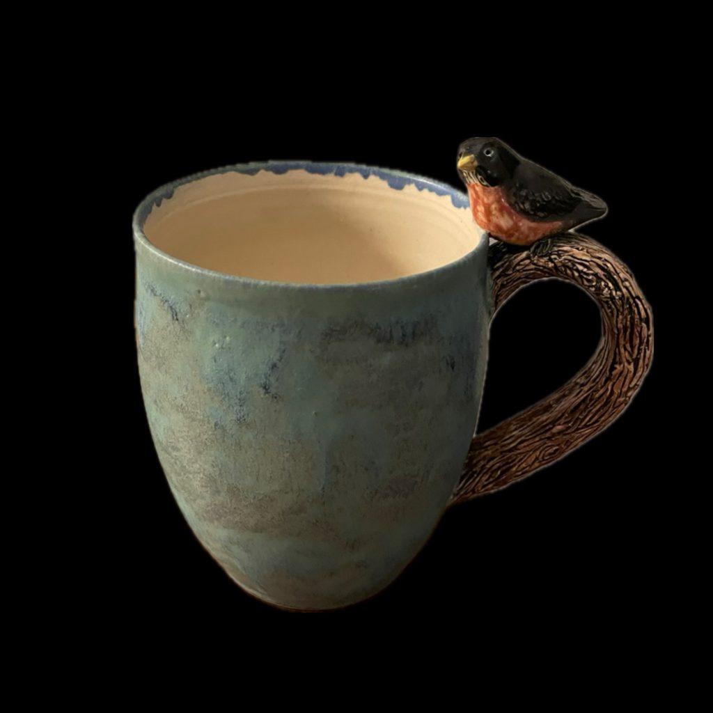 Large wheel-thrown, hand sculpted and underglaze-painted, glazed stoneware Robin mug with matte blue-green glaze and carved “branch” handle.