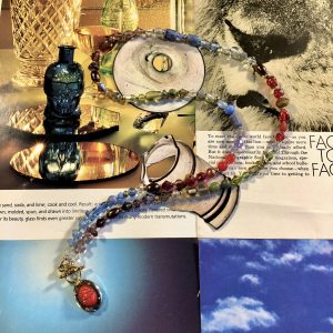 30” with a multicolor gradient of repurposed glass and crystal beads. It features a vintage gold plated scarab pendant on a gold plated toggle.